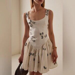 A revealing white dress with a shoulder-cut,in the style of Agua San Water Dance